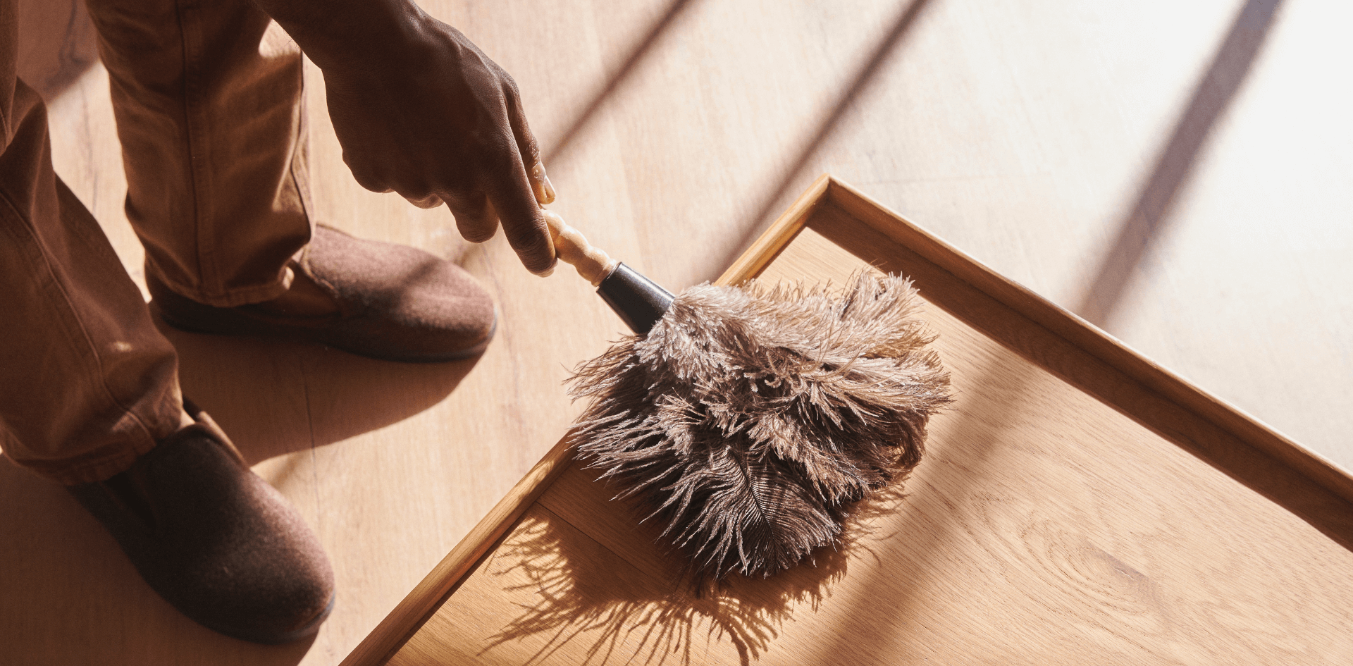 A man is dusting to remove home odors naturally.